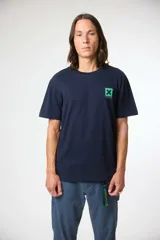 Remera de manga corta color azul marino, corte holgado, con un pequeño parche cuadrado verde con una 'X' y texto en japonés en el pecho izquierdo.