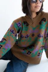 Buzo tejido de algodón negro con diseño jacquard de flores multicolor, cuello en V y mangas largas.