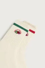 Pack de dos pares de calcetines blancos de canalé con detalles de rayas de colores en el borde superior y bordado del logo de Fruit of the Loom en el lateral.