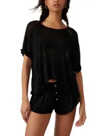Conjunto negro de short y remera de tejido traslúcido. El short tiene botones decorativos.