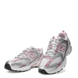 Championes New Balance modelo 530, con diseño retro deportivo. Presenta una base de malla blanca con superposiciones en cuero sintético plateado y detalles en color rosado. Incluye entresuela con tecnología ABZORB para mayor amortiguación.
