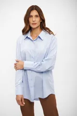 Camisa de corte oversize con cuello clásico, cierre frontal de botones y mangas largas con puños abotonados.