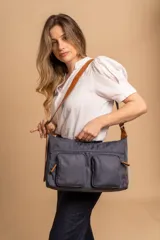 Bandolera de tafeta impermeable color beige, con dos bolsillos frontales con cierre y correa regulable. Diseño práctico y liviano ideal para uso diario.