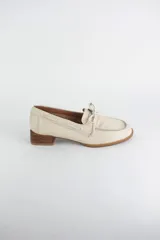 Mocasín náutico de cuero azul, con detalle de cordones en el empeine y taco cuadrado bajo simil madera.