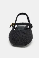 Zapato destalonado de tejido texturizado color negro, con punta cuadrada, tira delantera con hebilla metálica dorada y tacón bloque de acabado brillante.