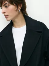 Tapado marrón de paño con doble botonadura, cuello solapa y bolsillos laterales.