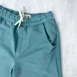 Short de algodón color celeste con cintura elástica ajustable con cordón y bolsillos laterales.