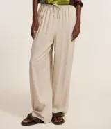Pantalón fluido de Blue Steel confeccionado en mezcla de viscosa y lino, color beige, con cintura elástica fruncida y lazo ajustable del mismo tejido. Presenta un corte holgado de pernera ancha.