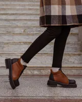 Botinetas de cuero combinadas en color negro y marrón, con diseño de paneles, cierre frontal y suela track dentada.