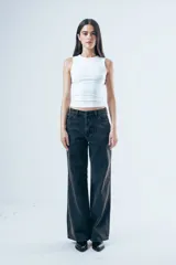 Jean de corte wide leg en color negro lavado, con tiro medio y cierre frontal con botón y cremallera.