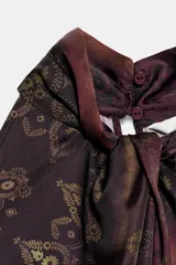 Top halter estampado de color bordó, con cuello alto, diseño sin mangas y cierre posterior con abertura y botón.