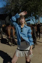 Camisa celeste de jean fino, de corte clásico y mangas largas con puños abullonados.