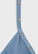 Top de bikini triangular color celeste con detalle de eyelets metálicos. Se ata en la espalda con lazo y tiene relleno.