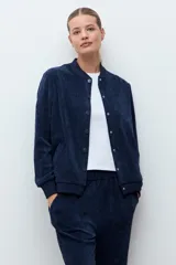 Campera tipo bomber de tejido acanalado en color azul marino, con cuello redondo, cierre frontal con botones a presión y puños elásticos.