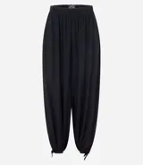 Pantalón estilo aladino color bordó, confeccionado en tejido crepé con textura. Presenta cintura elástica, corte holgado en las piernas y ruedo ajustado con lazo decorativo.