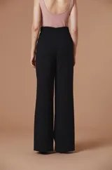 Pantalón de vestir negro de talle alto y corte recto con silueta amplia y caída fluida.