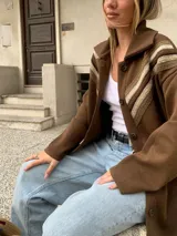 Saco marrón de lana con cuello camisero, cierre con botones y detalle de crochet en los hombros.