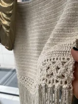 Falda tejida a mano en crochet, color crudo, con flecos en el ruedo y abertura lateral.