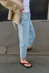 Jeans de tiro medio con cinco bolsillos, pernera recta y corte cropped. Cierre frontal con cremallera y botón.