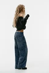 Jeans baggy de tiro medio con cinco bolsillos, trabillas para cinto y cierre frontal con cremallera y botón metálico. Cuenta con detalle de aplicación de brillos en toda la prenda.