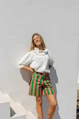 Camisa blanca de manga larga con cuello con volados y cierre frontal de botones.