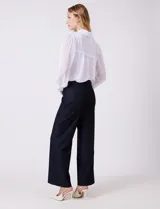 Pantalon de corte wide leg y tiro alto, con cintura estructurada, pasadores para cinturon y cierre frontal con gancho. Presenta bolsillos laterales de ojal y bolsillos traseros simulados, confeccionado en un tejido con caida fluida.