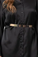 Cinto fino de metal dorado con eslabones rectangulares, que termina en una cadena ajustable a la cintura.