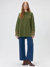 Sweater de cuello redondo con diseño de tejido en relieve de rombos, manga larga y calce holgado. Presenta logo bordado en el pecho y aberturas laterales en el ruedo.