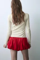 Shorts de tiro medio confeccionados en satén rojo, con diseño tipo globo y cintura elástica ajustable mediante cordones. Presentan detalles de encaje blanco en los laterales.