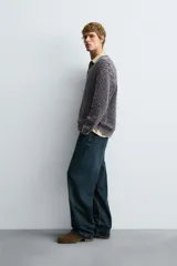 Polo relaxed fit de punto jacquard geométrico en hilatura de algodón, color morado con efecto lavado. Tiene cuello solapa, cierre frontal de botonadura y manga larga con acabados en rib.