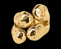 Anillo de bronce dorado con diseño orgánico y escultural, compuesto por cuatro volúmenes irregulares texturizados que se conectan entre sí.