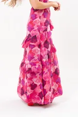 Vestido largo fucsia con estampado abstracto, cuello halter con abertura en forma de lágrima y volados en la falda.
