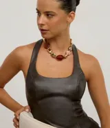 Collar maxi estructurado confeccionado en metal reciclado con baño light gold. Presenta un diseño orgánico y asimétrico con piedras de resina en diferentes tamaños y formatos en tonos ámbar, dorado y rosado.