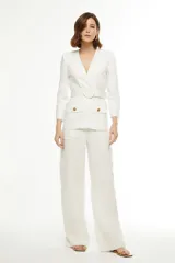 Blazer amarillo con solapas, corte entallado, cierre cruzado con botón y cinturón con hebilla redonda.