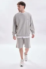 Sudadera gris claro con efecto lavado, de corte holgado y manga larga. Presenta una estampa minimalista en la espalda con el texto 'city pulse', 'street vibe' y 'subway beat'.