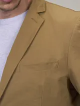 Blazer color marrón claro, de corte clásico, con solapas de muesca, cierre de dos botones, bolsillo en el pecho y bolsillos laterales con solapa.