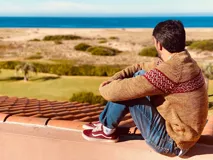 Sweater de lana merino color beige con diseño geométrico en el pecho en tonos rojo y blanco.