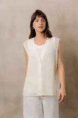 Chaleco de tejido de punto calado, color blanco, de silueta amplia y relajada, escote en V, cartera frontal con botones y terminaciones acanaladas.