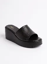 Sandalia de plataforma tipo zueco color marrón, confeccionada en cuero vacuno, con capellada ancha y taco chino forrado.