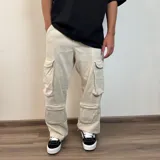 Pantalón de jean estilo cargo con corte baggy, color azul lavado. Presenta cuatro bolsillos laterales de gran tamaño con solapa y cierre de botones, diseño de pierna ancha y tiro medio.