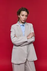 Blazer beige de corte recto, con solapa clásica, bolsillos frontales con solapa y cierre de un botón.