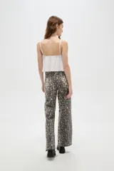 Pantalon de jean de corte ancho y tiro alto, con estampado tipo animal print desgastado en tonos gris y blanco.