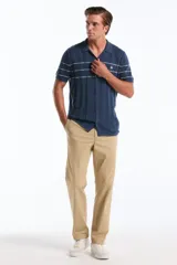 Polo cardigan azul de tejido de punto con rayas horizontales blancas en el pecho, cuello camisero y cierre frontal de botones.
