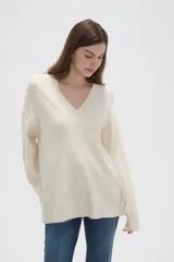 Sweater de punto con diseño de ochos, color rojo, con cuello en V y mangas largas de corte holgado.