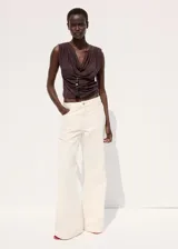 Jeans de algodón tiro medio, diseño acampanado estilo flare de corte largo, con trabillas, cinco bolsillos y cierre frontal de botón y cremallera.