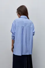 Camisa de manga larga con diseño de rayas verticales blancas y verdes, calce relajado, cuello clásico y botonadura frontal con botones perlados.