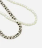 Set de dos collares: uno de cadena plateada de eslabones gruesos y otro de perlas sintéticas.