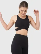 Top deportivo negro de escote redondo, con bandas elásticas cruzadas bajo el busto y abertura en la espalda.