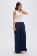 Pantalón jean azul de tiro medio, corte holgado y diseño amplio con pinzas en la parte frontal.