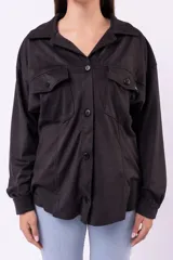 Camisa de estilo sobrecamisa en color beige, confeccionada en tela tipo gamuza o cuero sintético. Presenta cuello clásico, cierre frontal con botones, bolsillos delanteros con solapa y mangas largas con puños abotonados.